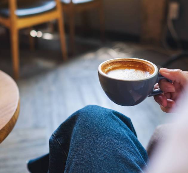 Closeup image of a woman holding and drinking hot coffee Closeup image of a woman holding and drinking hot coffee
